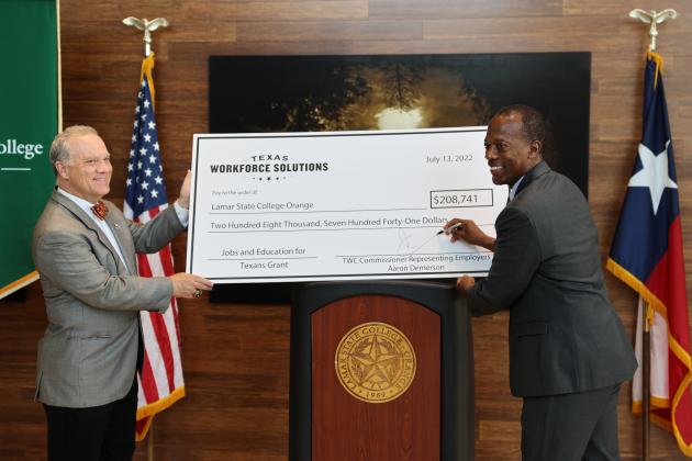 TWC Commissioner Representing Employers Aaron Demerson (right) signs and presents a JET Grant check to Lamar State College President Dr. Tom Johnson.